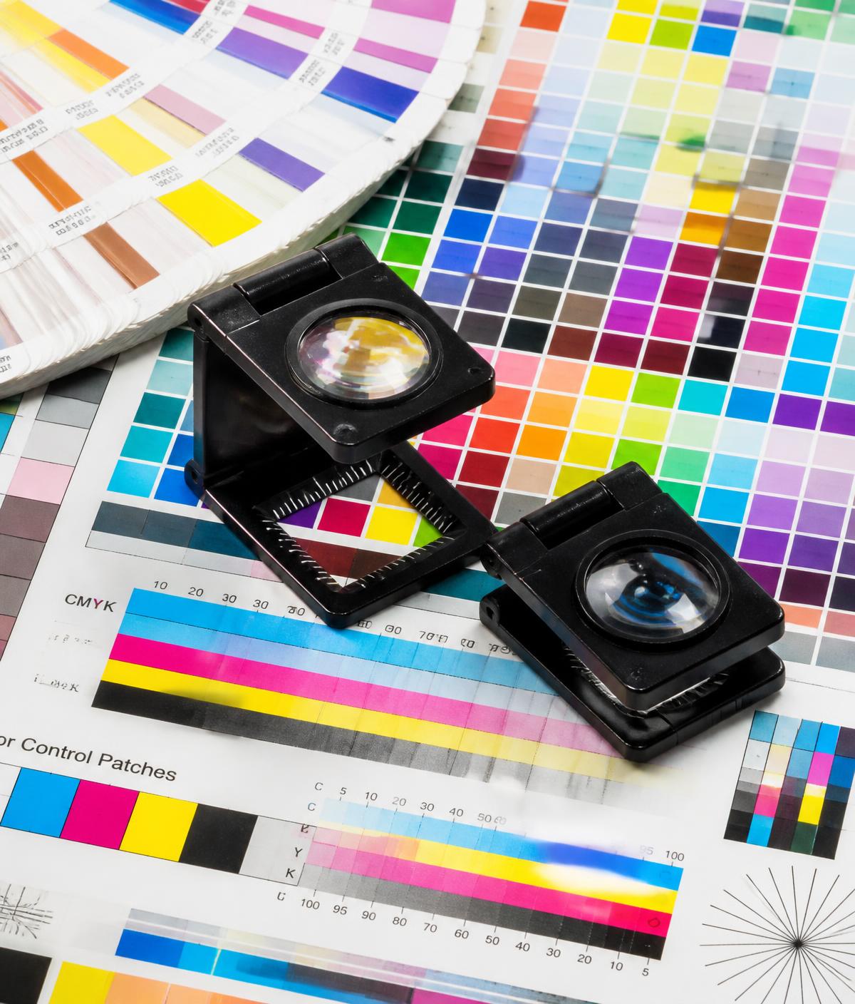 Lupas cuentahílos sobre pruebas de color CMYK impresas